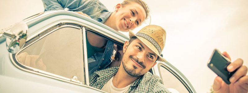 Happy couple on vintage car - Two friends photographing on a road trip - Concepts of couple,travel and fun