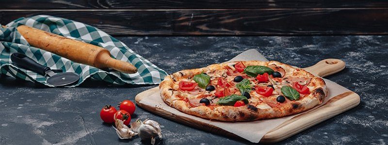delicious Neapolitan pizza on a blackboard with cherry tomatoes, free space for text